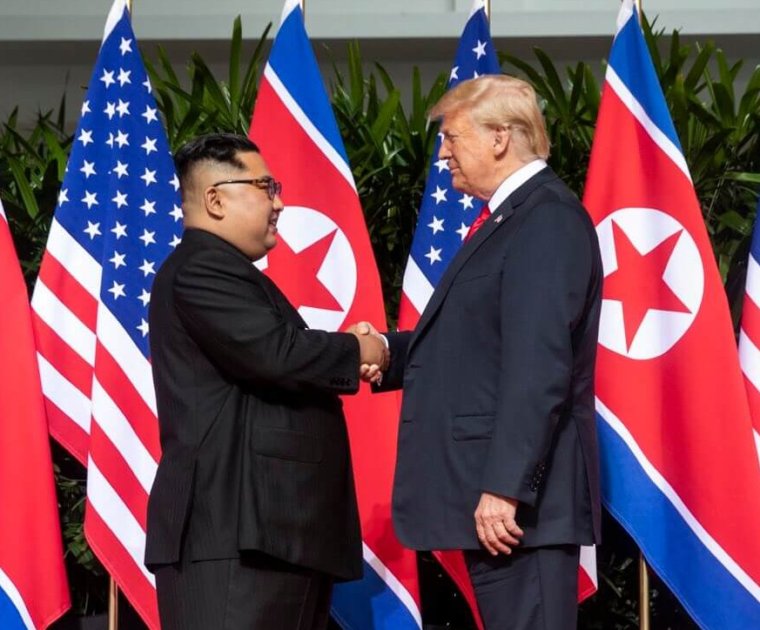 Kim and Trump shaking hands at the red carpet during the DPRK–USA Singapore Summit e1599132464464
